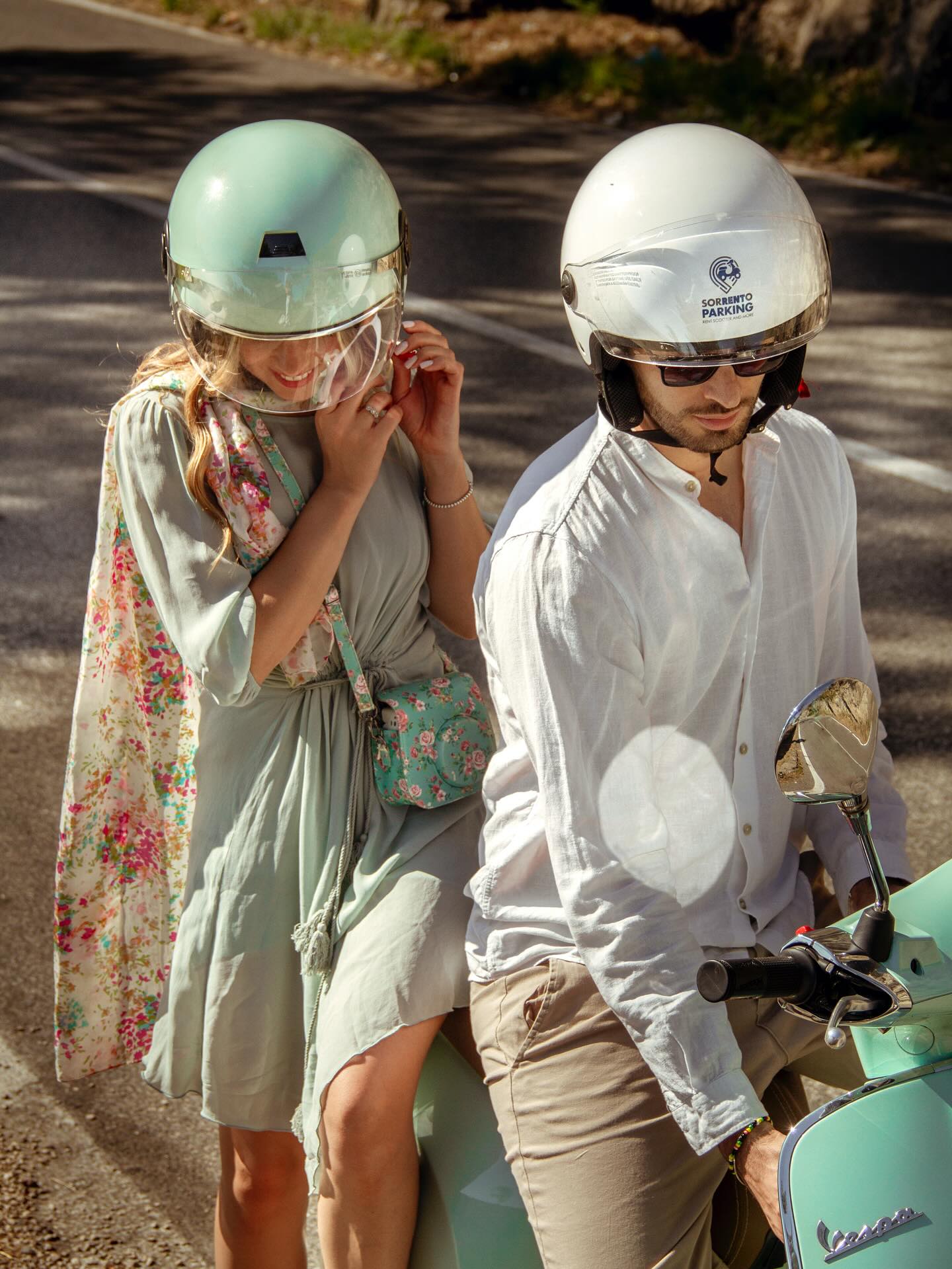 coppia sedute su una vespa verde